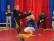 Zwei Kinder machen Capoeira: Eines führt einen hohen Kick aus, während das andere unter dem Bein hindurchtaucht