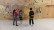 Drei Schülerinnen und Schüler stehen vor einer Kletterwand 