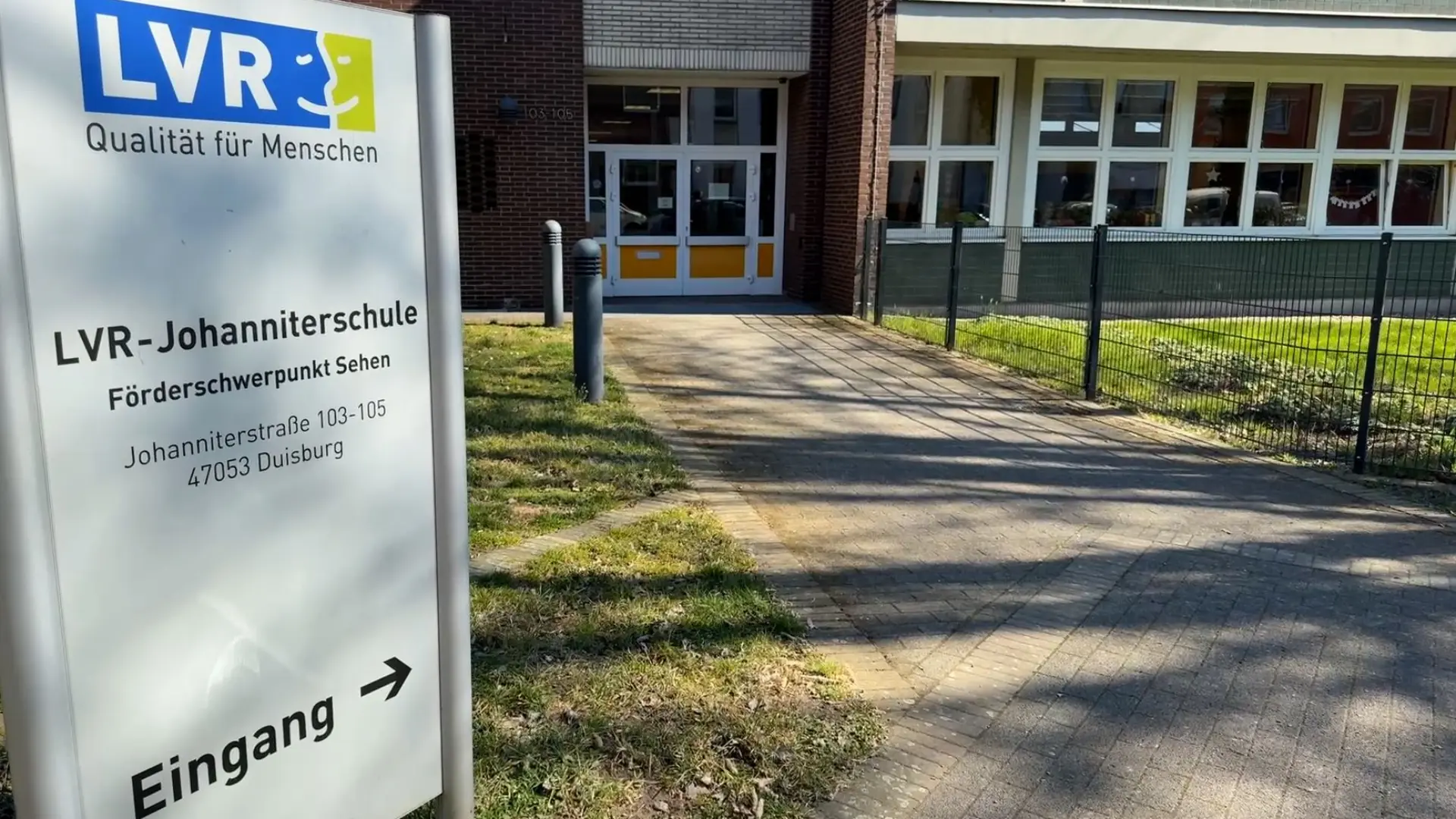Eingangsbereich der LVR-Johanniterschule, im Vordergrund das Einganssschild mit der Beschriftung: LVR-Johanniterschule, Förderschwerpunkt Sehen. Johanniterstraße 103–105, 47053 Duisburg