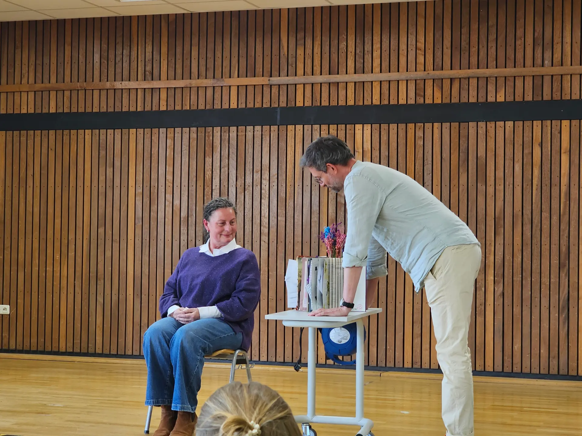 Mehrere Schülerinnen und Schüler stehen auf der Bühne und führen ein Theaterstück auf. 