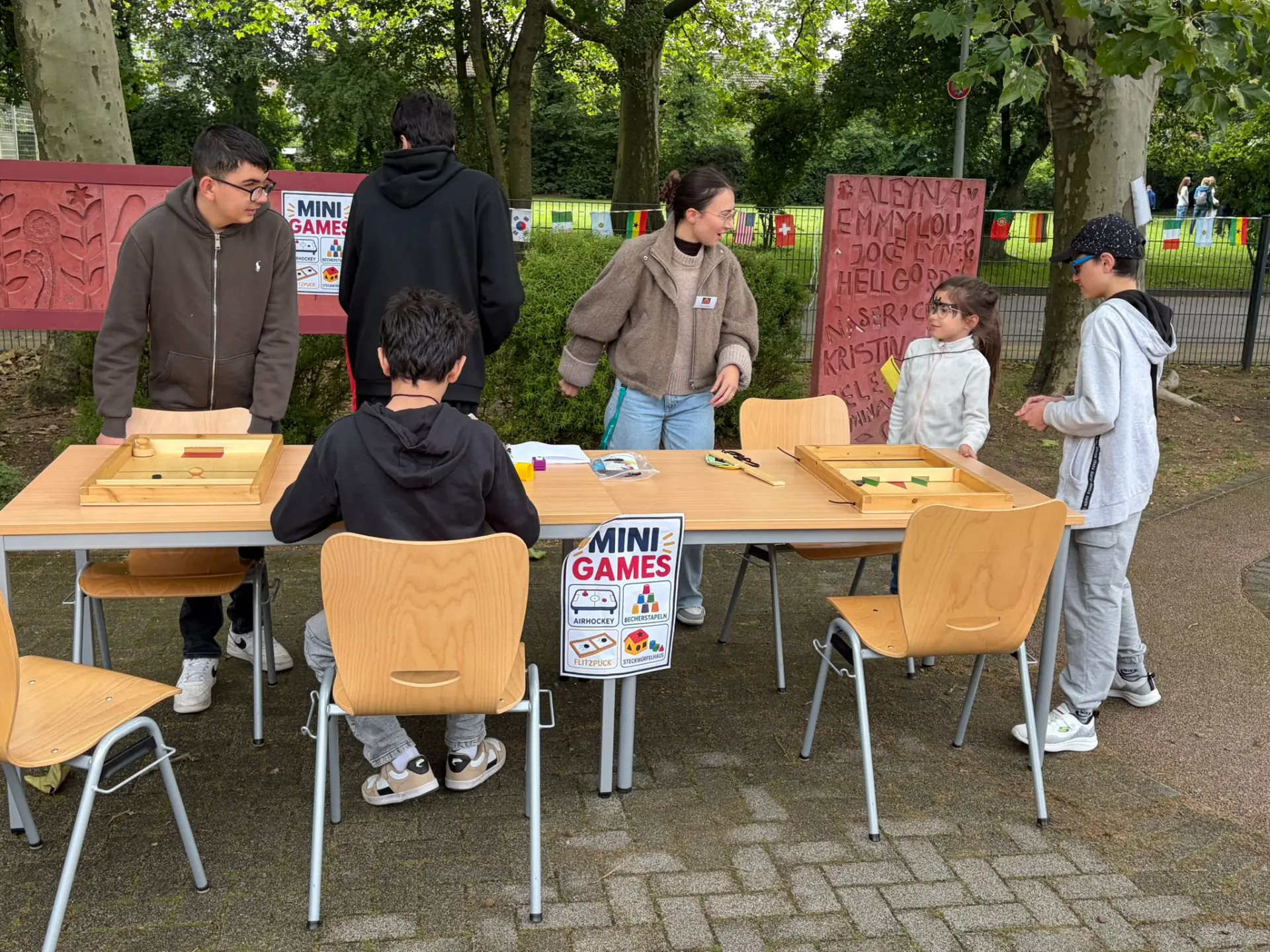Schülerinnen und Schüler spielen gemeinsam verschiedene Mini-Spiele an einem Aktionsstand.