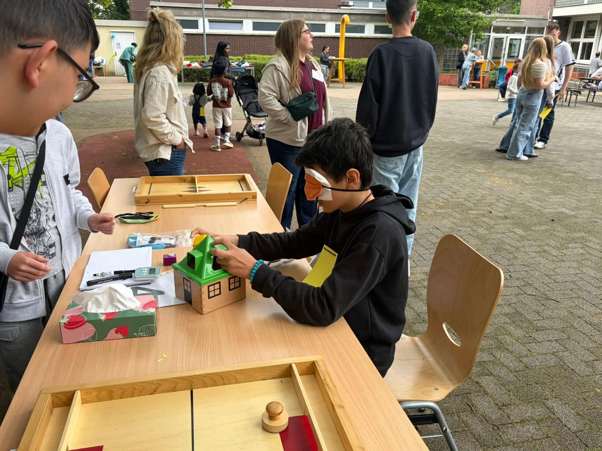 Schüler probiert mit verbundenen Augen ein Steckspiel aus