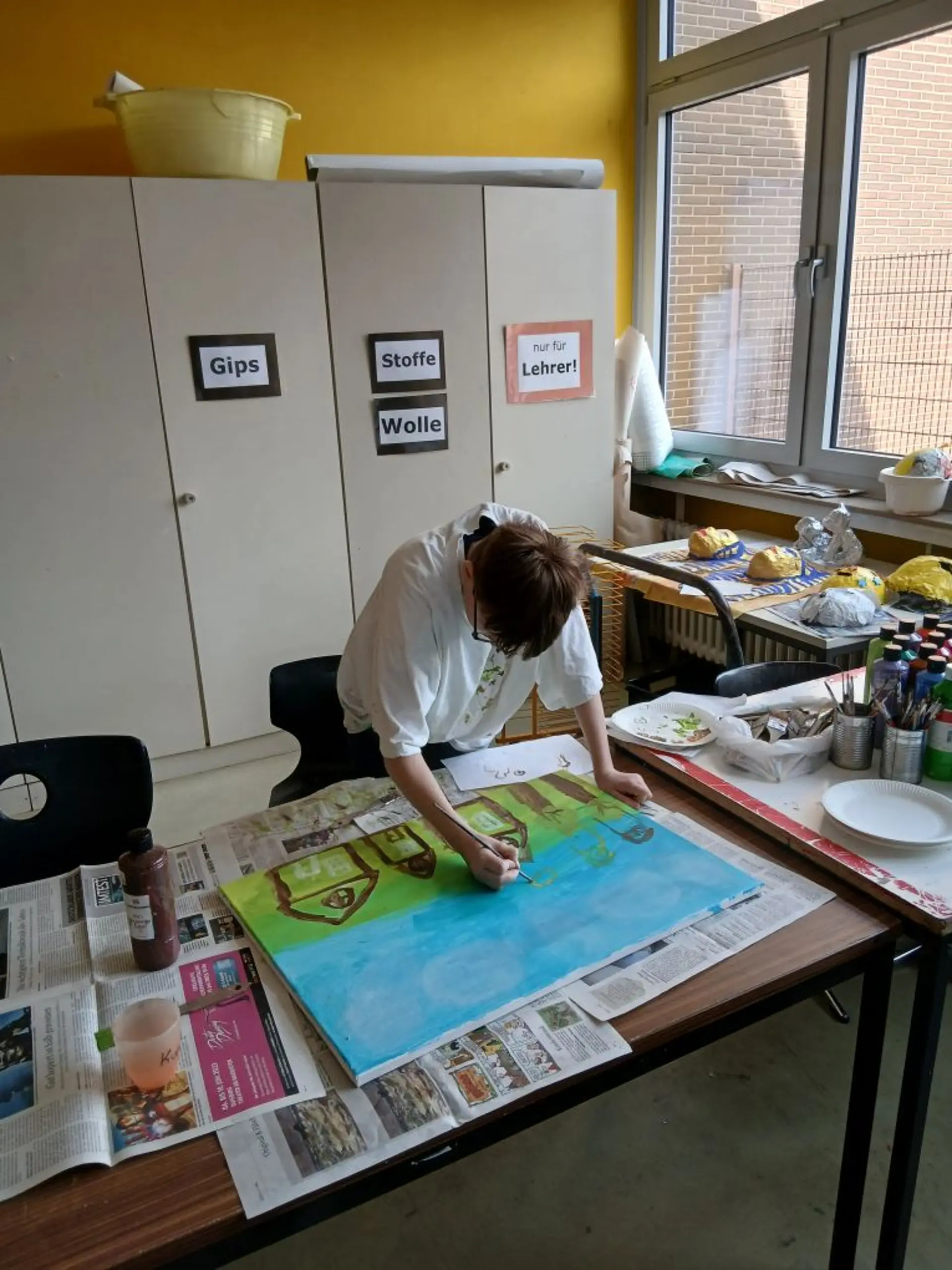 Eine Person malt ein Bild auf einer Leinwand