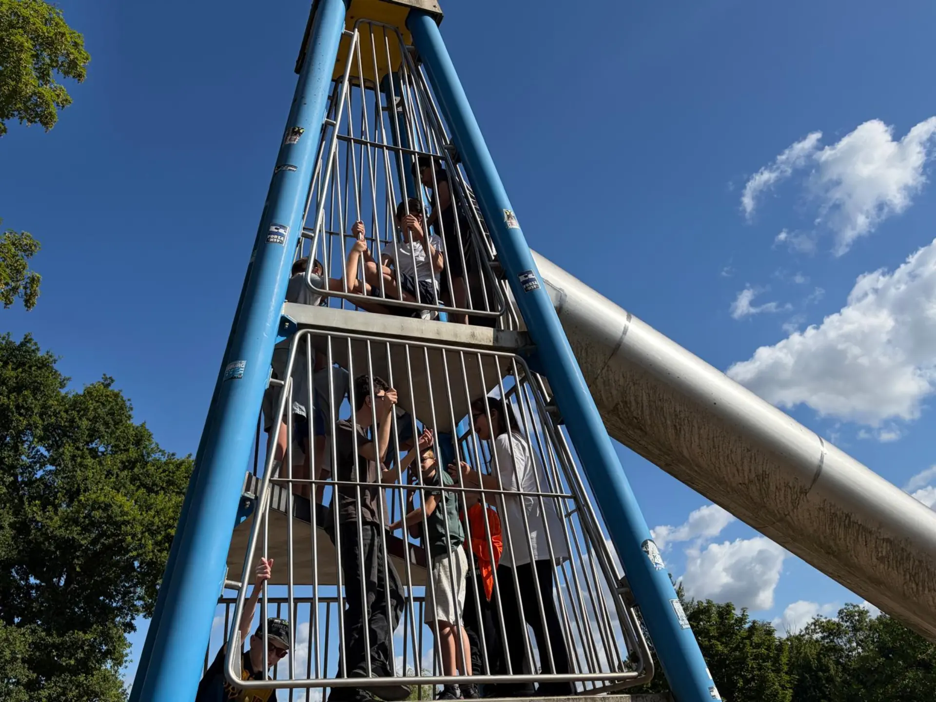 Schülerinnen und Schüler befinden sich auf dem Gerüst, welches zu einer Rutsche führt 