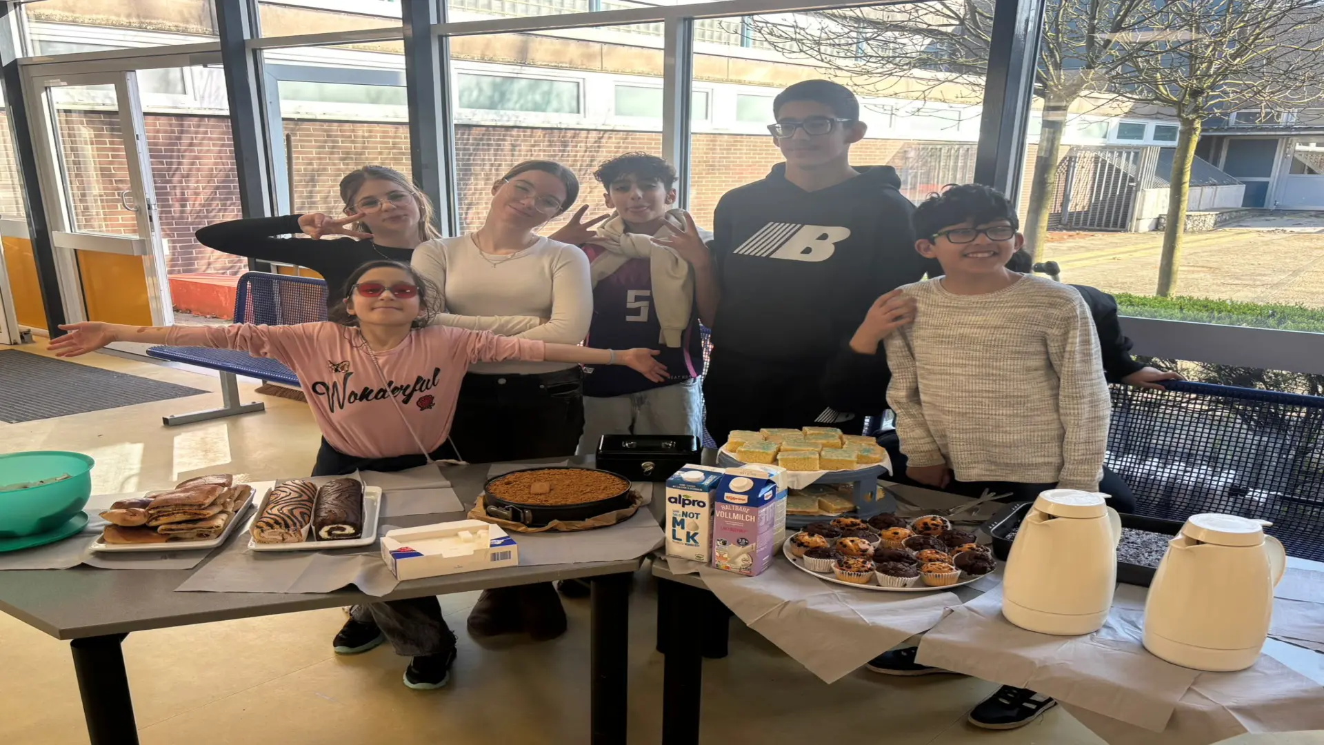 Mehrere Schülerinnen und Schüler stehen auf der Bühne und führen ein Theaterstück auf. 