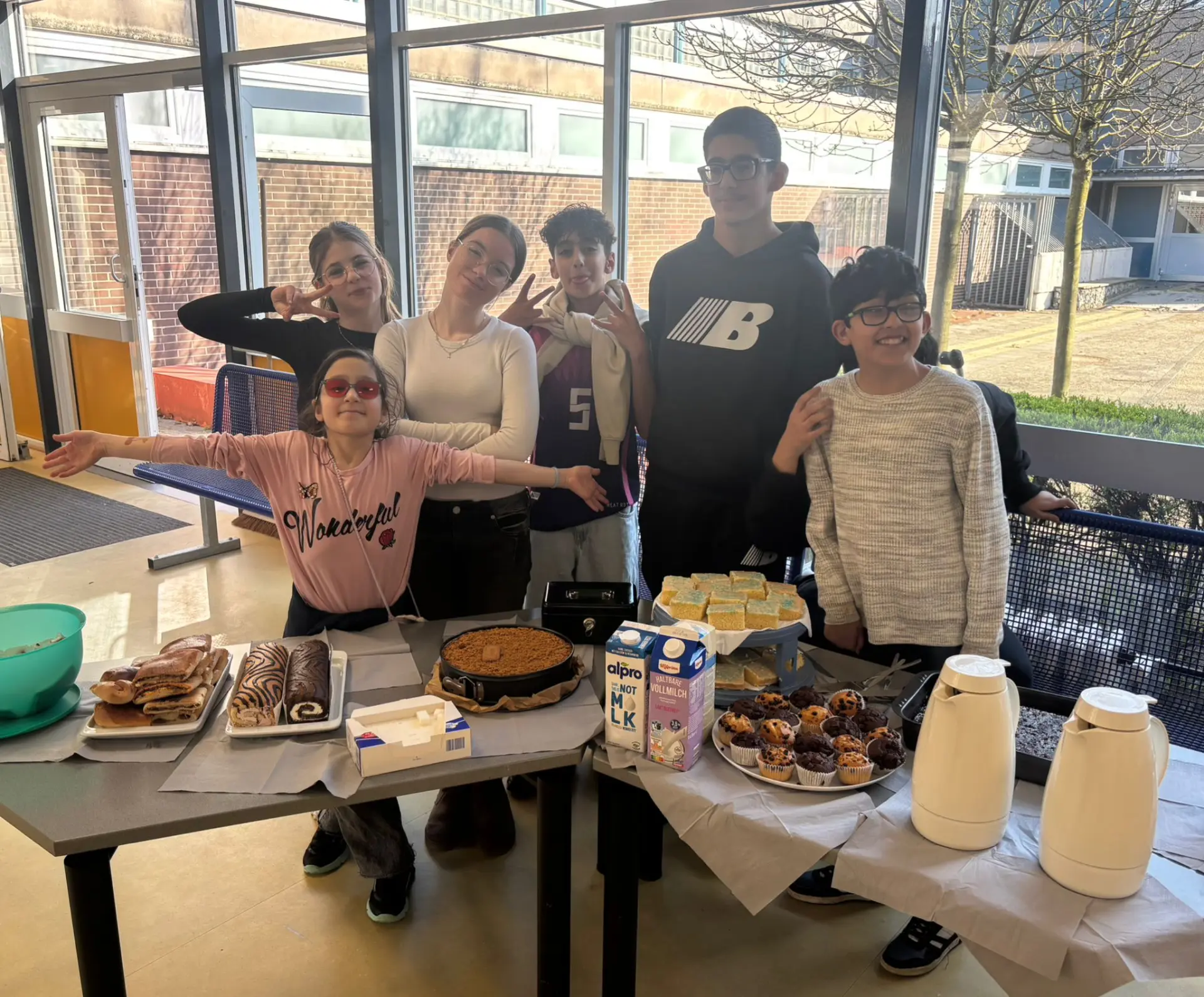 Mehrere Schülerinnen und Schüler stehen auf der Bühne und führen ein Theaterstück auf. 