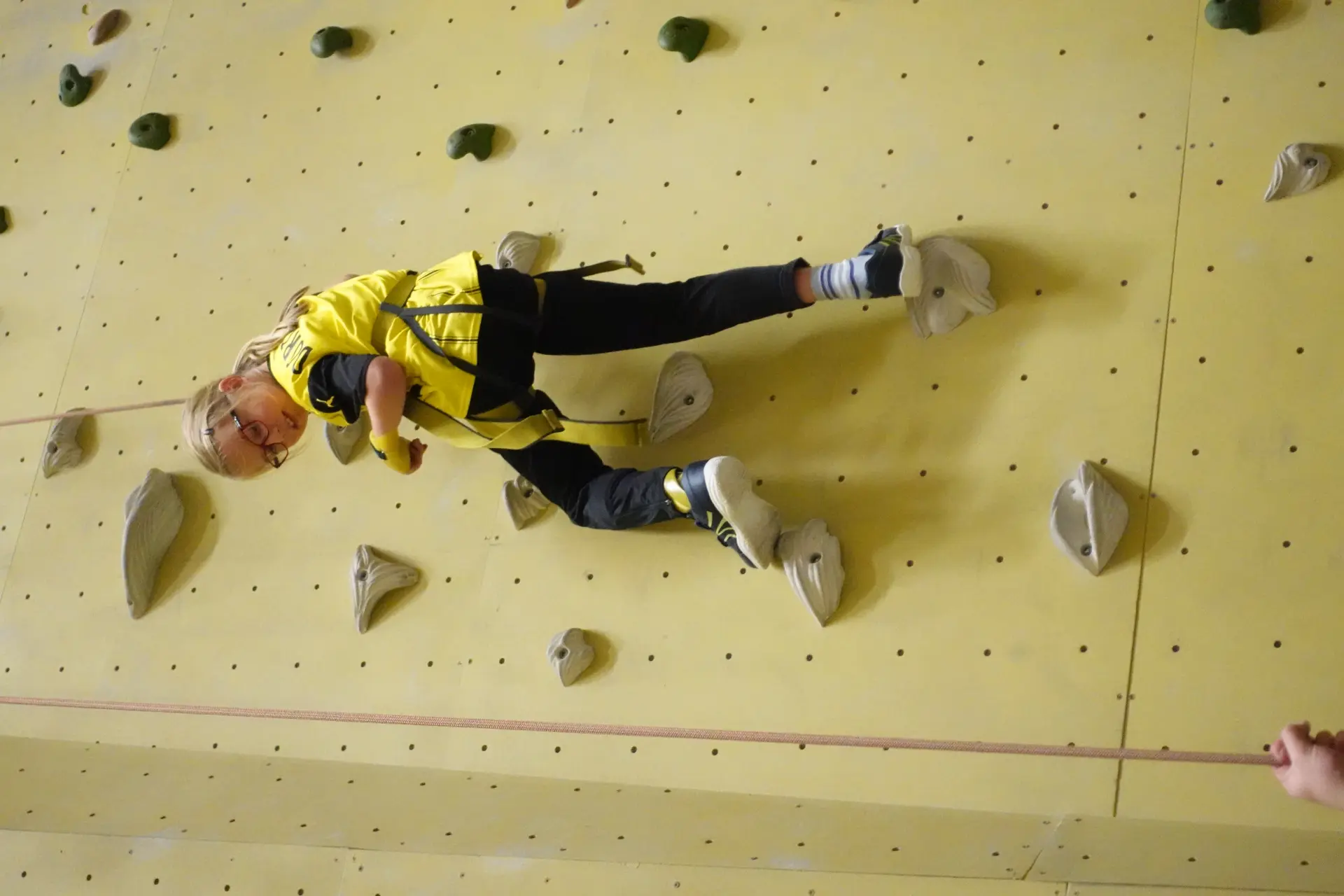 Eine Frau steht hinter einem Tisch, auf dem verschiedene Kuchen stehen. Sie lächelt freundlich. Auf einem weiteren Tisch stehen Getränke. Dahinter sind drei Jugendliche, die die Getränkeausgabe betreuen.