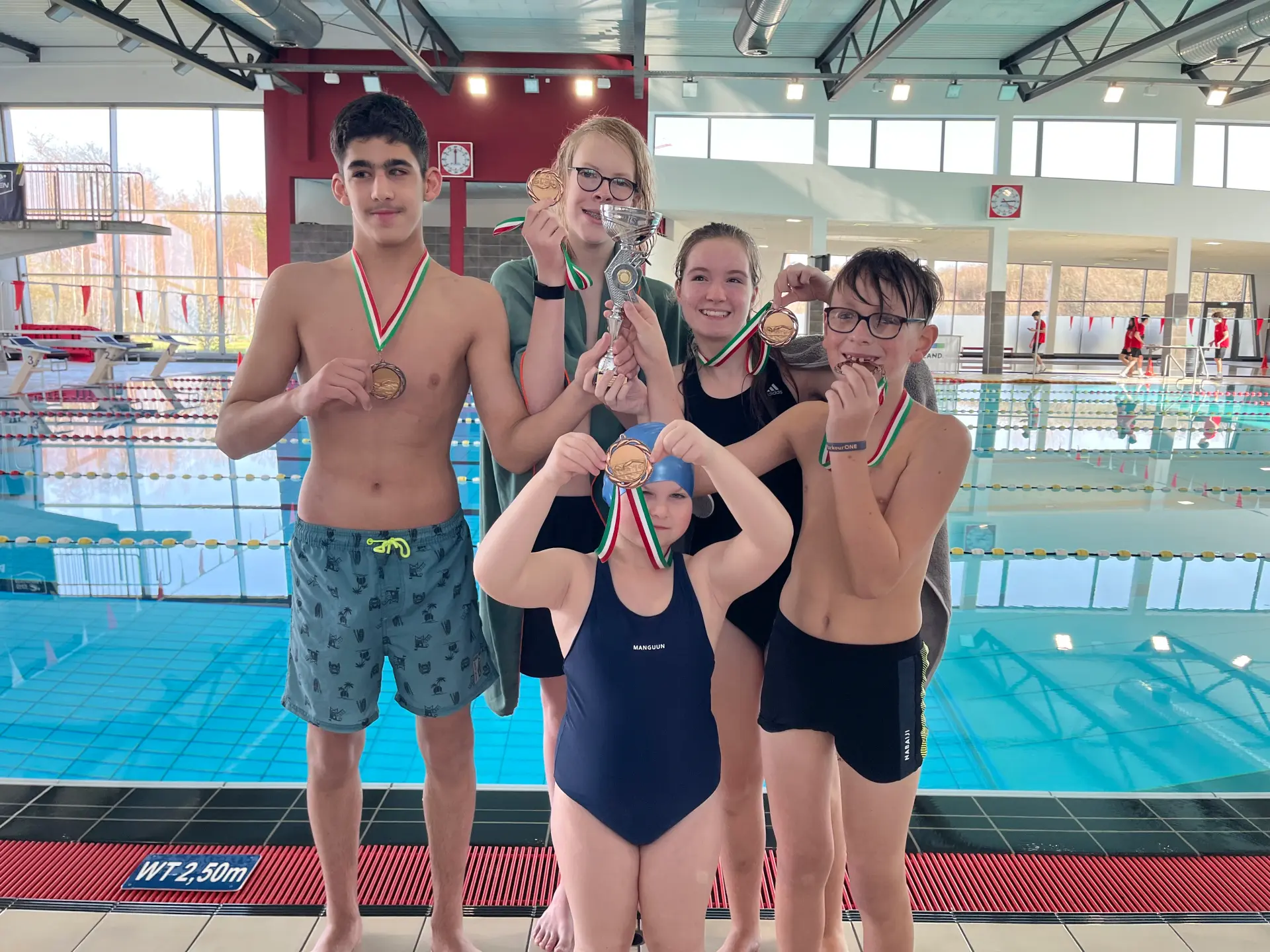 Mehrere Schülerinnen und Schüler stehen auf der Bühne und führen ein Theaterstück auf. 