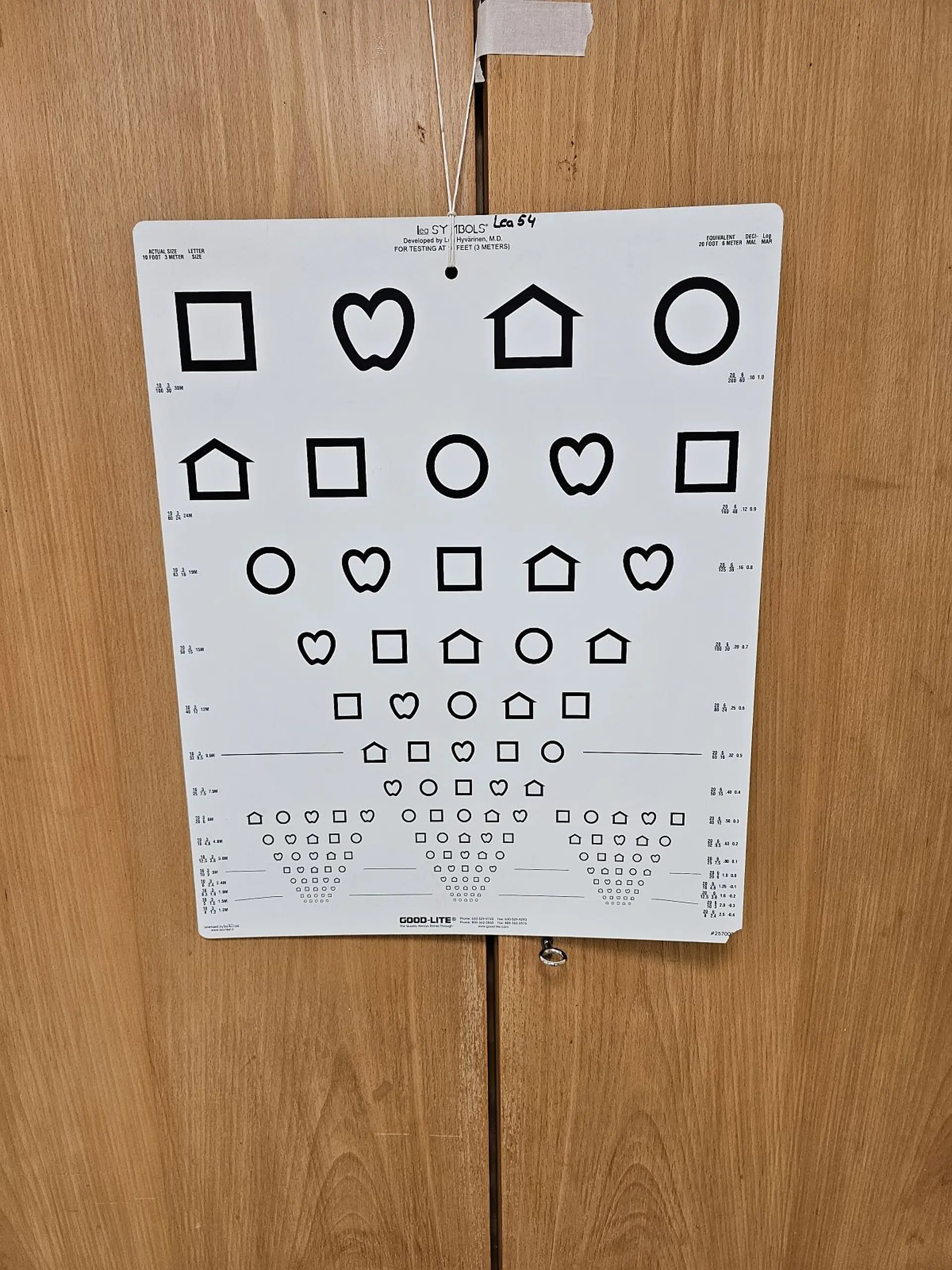 An der Wand hängt ein weißes Plakat mit schwarzen Formen, die immer kleiner werden.