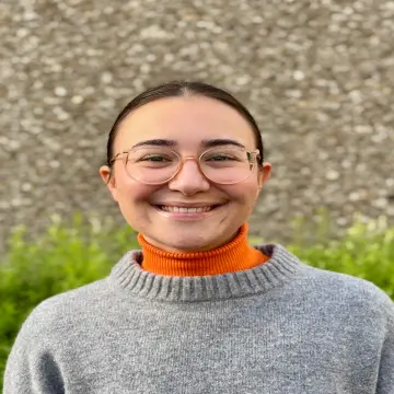 weibliche Lehrkraft mit Brille und braunem Pferdeschwanz